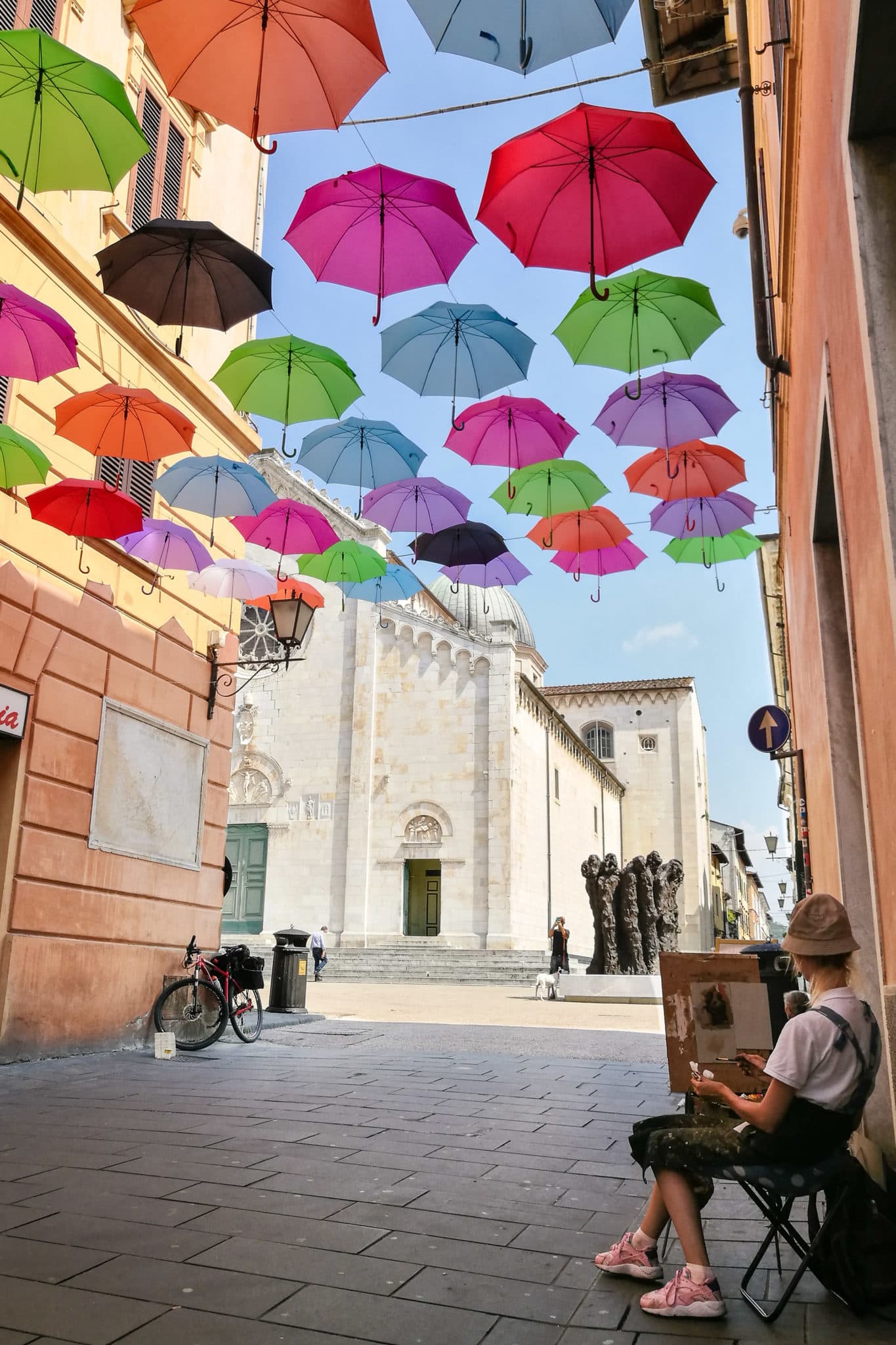 Painter under the floating umbrellas in Pietrasanta
